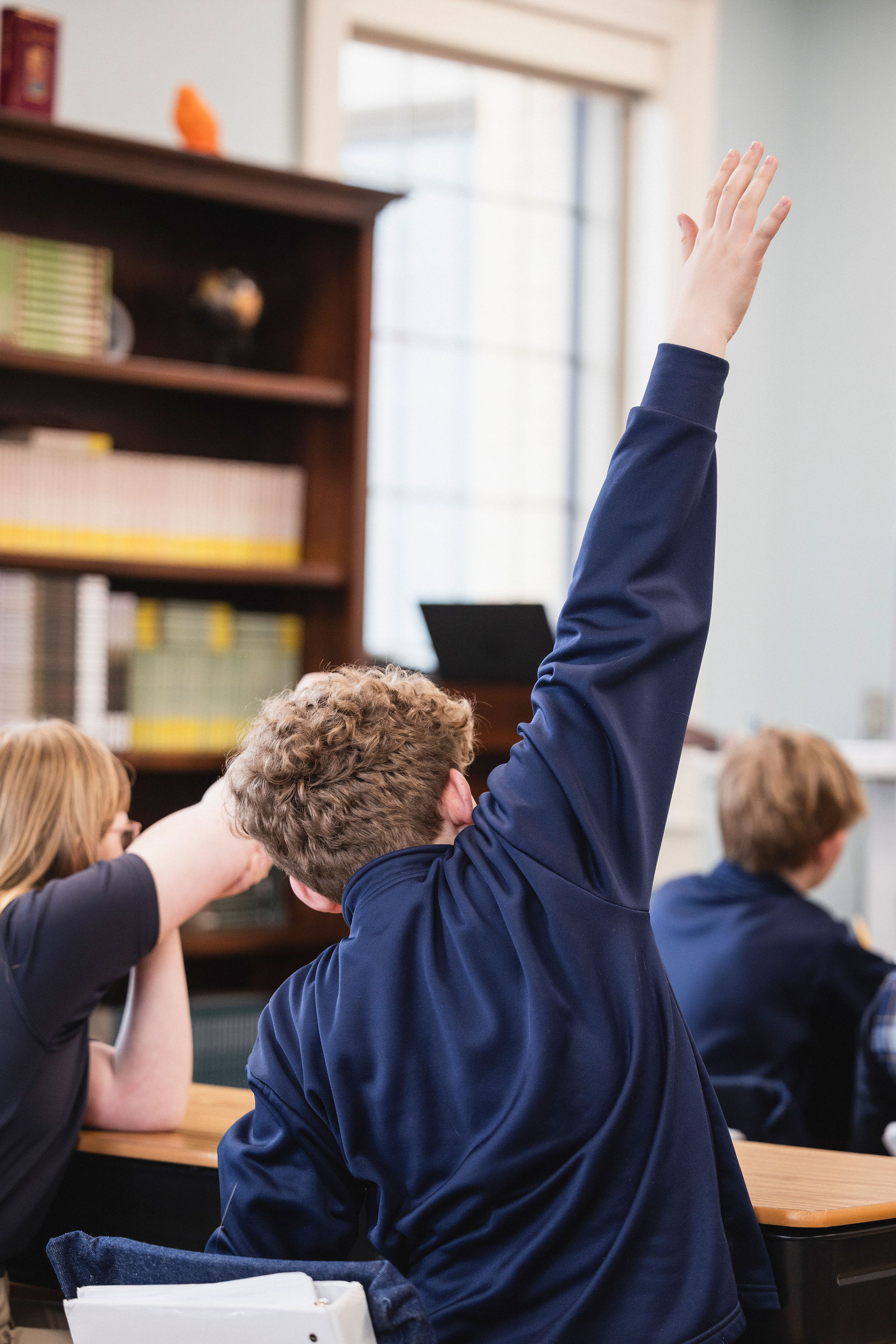 boy raising hand enthusiastically
