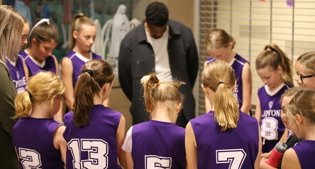 Basketball players huddled in prayer