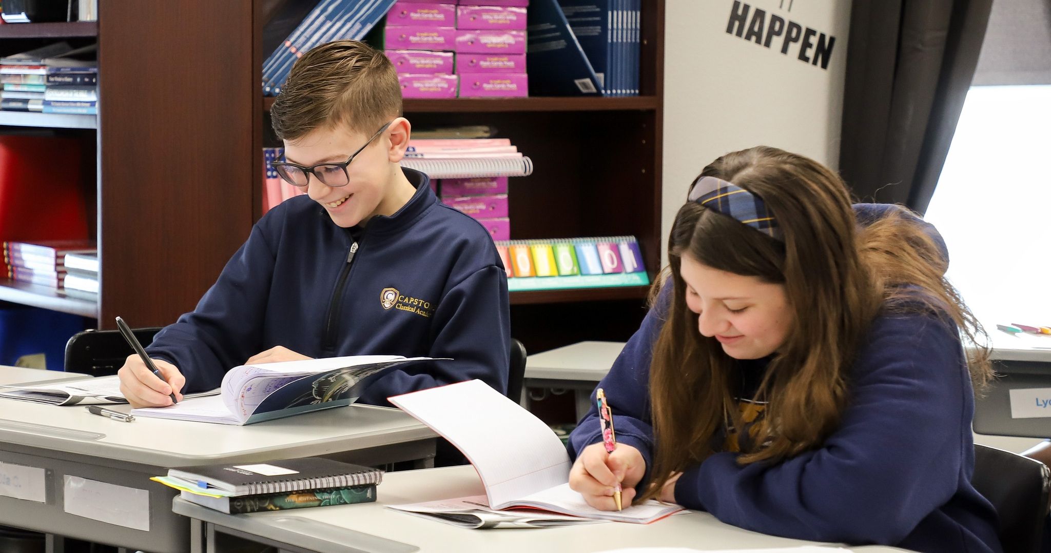 Two students laughing and working